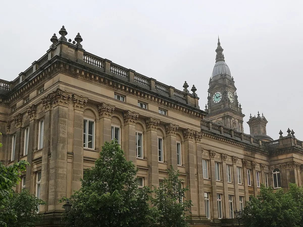 Bolton: a stone town hall with a columned portico and clock tower above a civic square