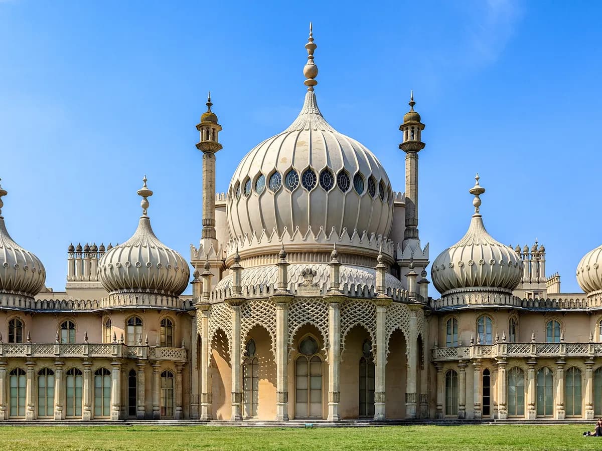 Brighton: a pier reaching out over the sea beside an onion-domed royal pavilion, pebble beach in front