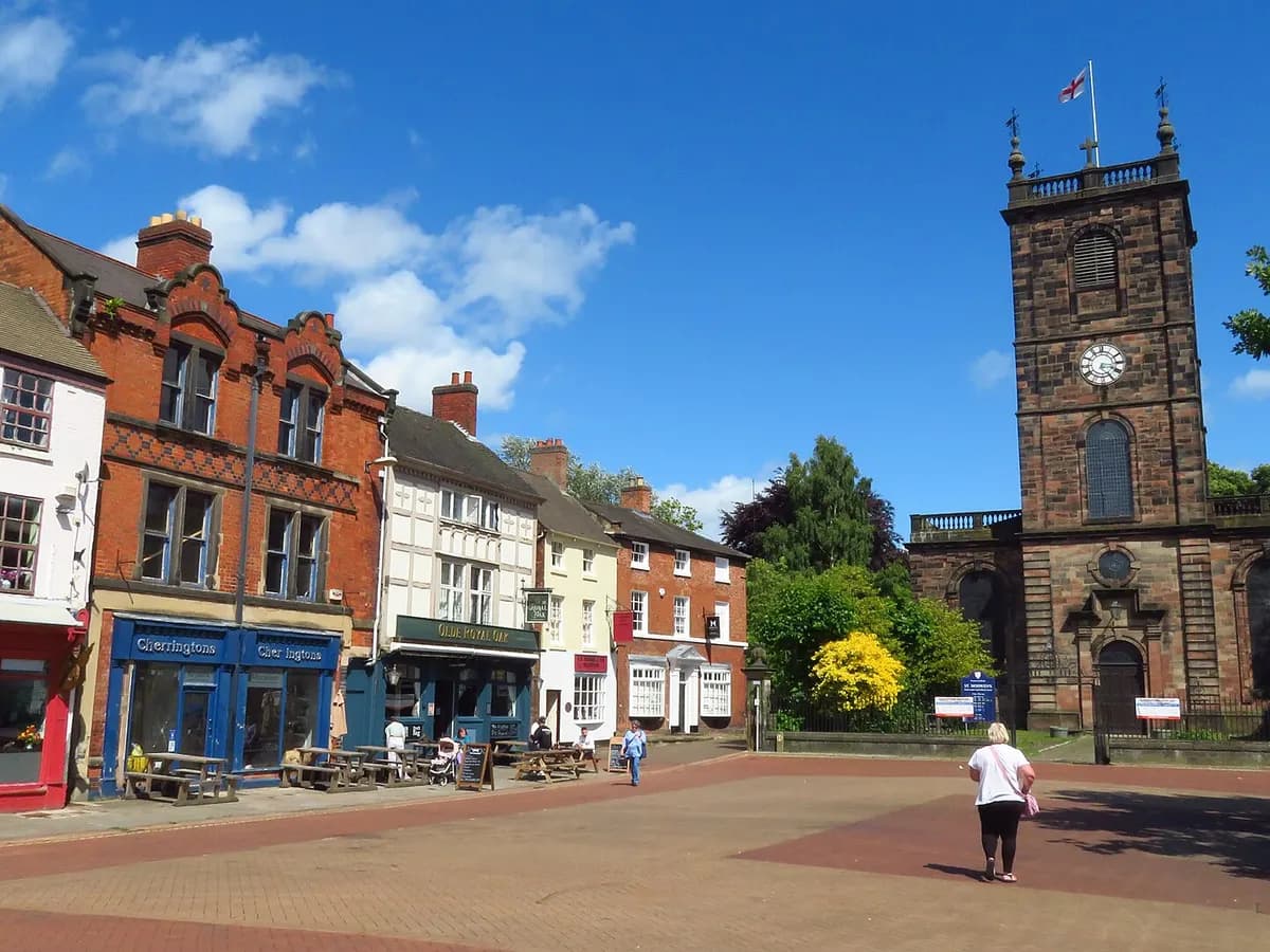 Burton upon Trent: brewery buildings with chimneys and stacked wooden barrels beside a river