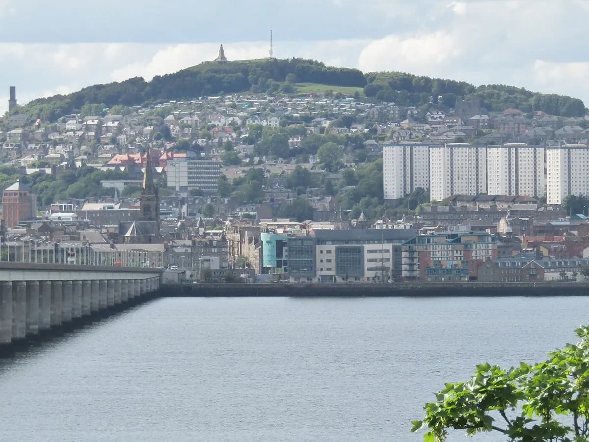 Dundee: an angular stone waterfront museum like a cliff, a long rail bridge crossing the firth