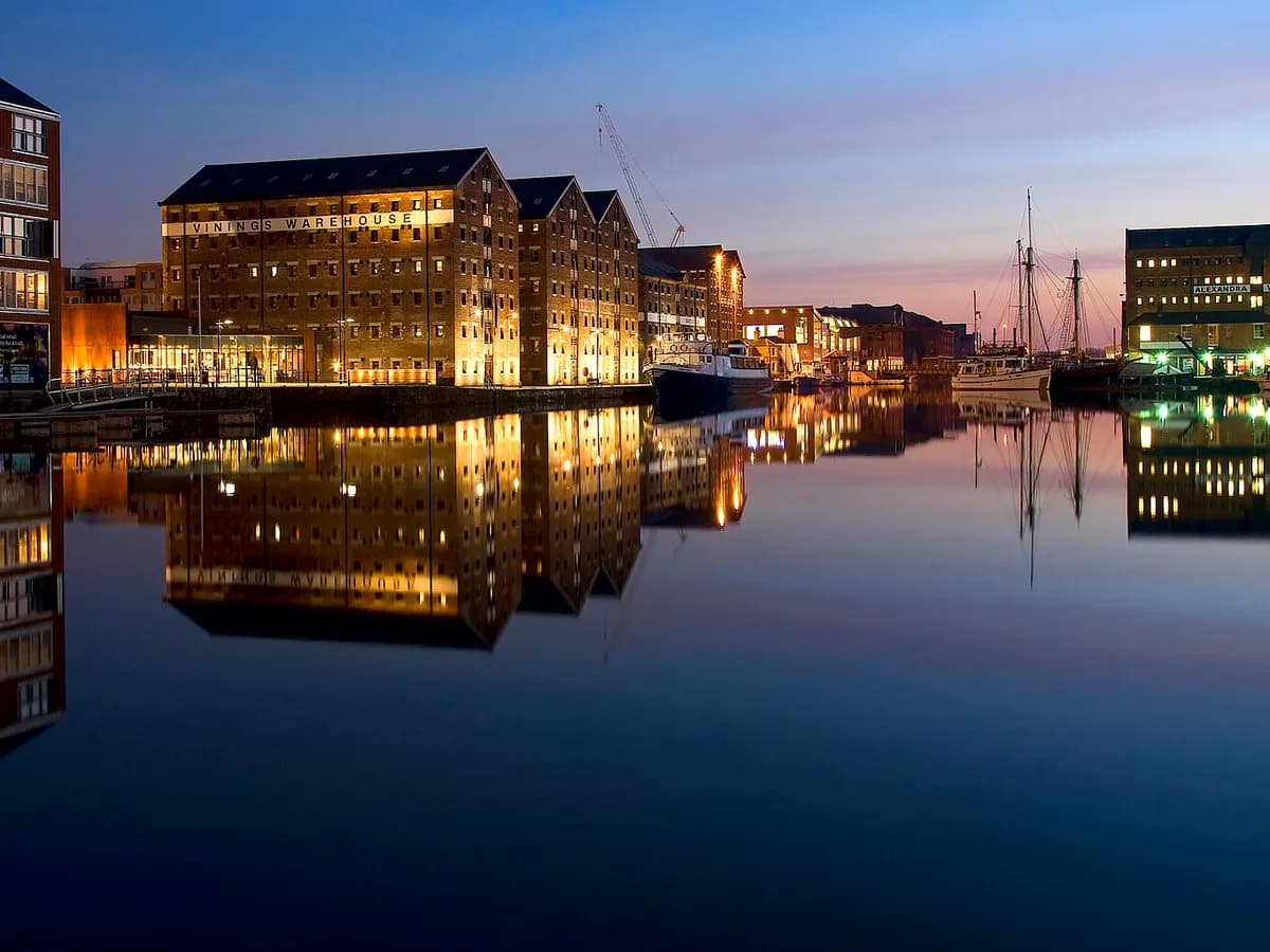Gloucester: a cathedral tower above restored brick dock warehouses and moored boats