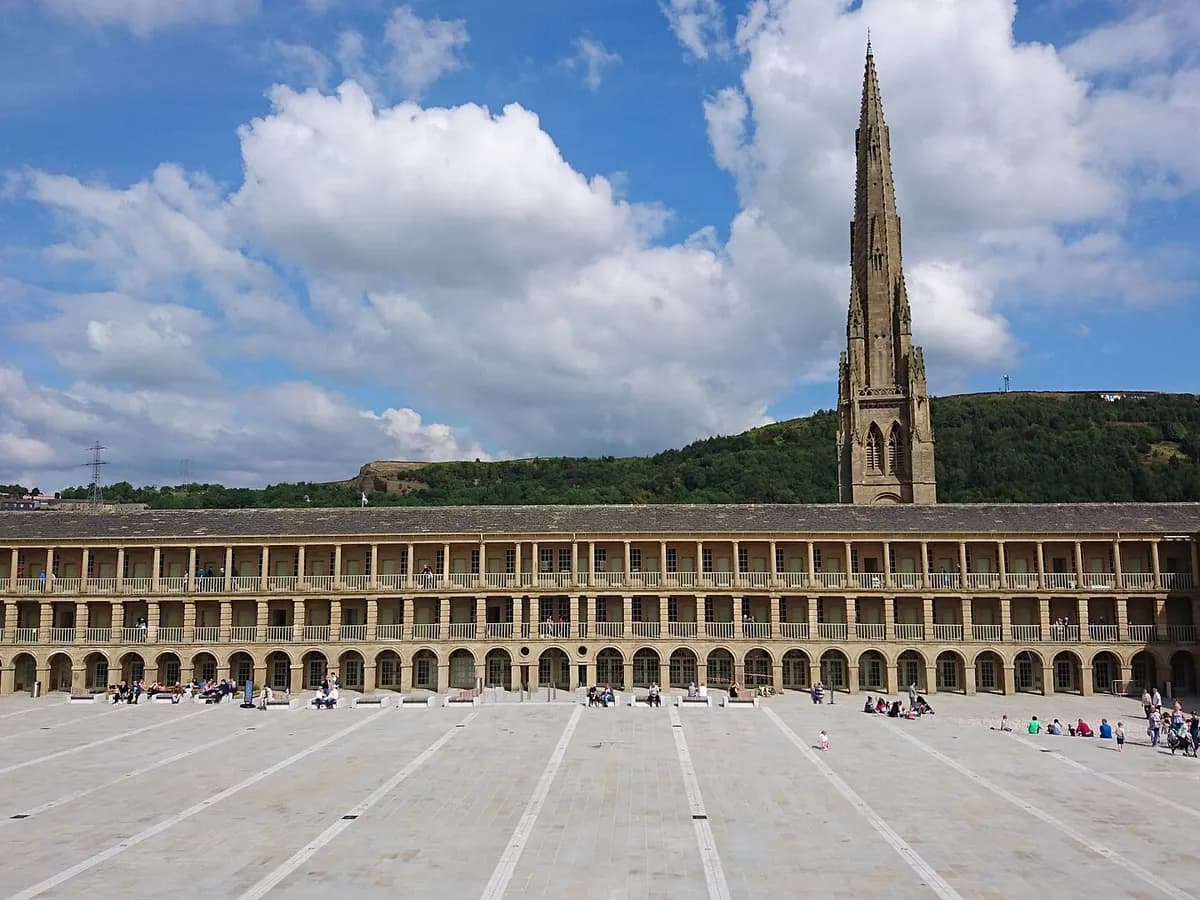 Halifax: a huge stone quadrangle of colonnaded cloth-hall galleries below a hillside of terraces