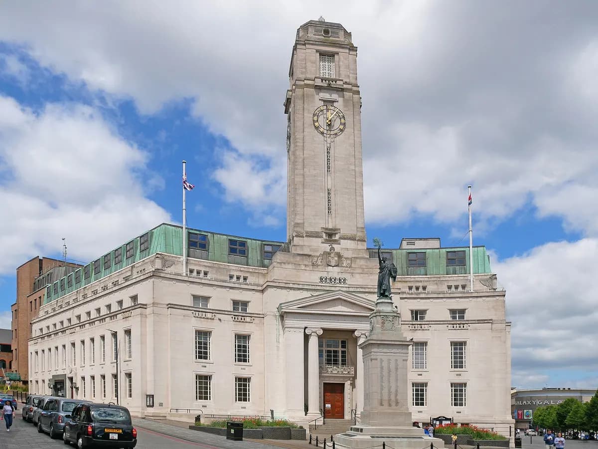 Luton: a red-brick town hall with a clock tower, an airliner climbing away over the rooftops