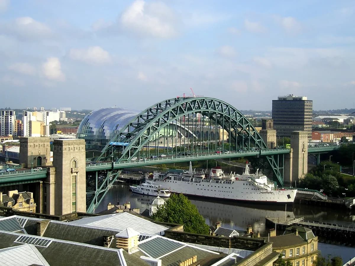Newcastle upon Tyne: a great green steel arch bridge over a river with quayside buildings below
