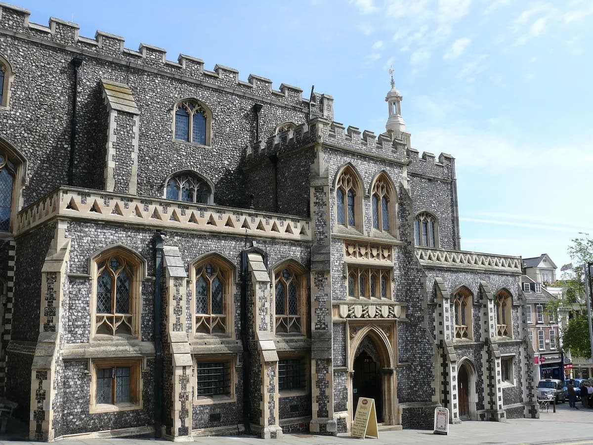 Norwich: a Norman castle keep on a mound and a cathedral spire above a market of coloured stalls
