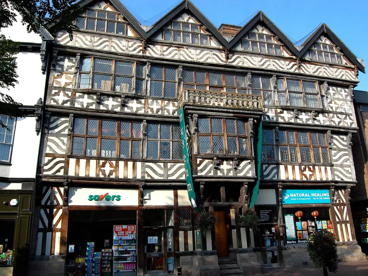 Stafford: a tall timber-framed Elizabethan house on the street, a castle on the hill beyond