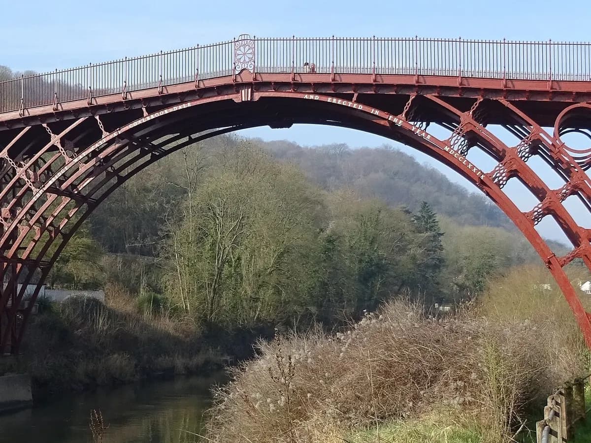 Telford: a single cast-iron arch bridging a wooded gorge above a river