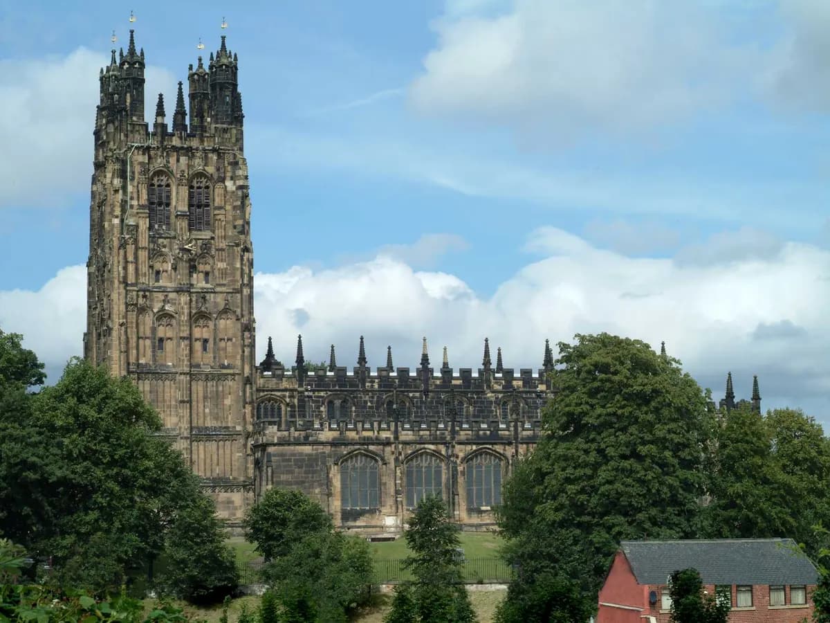 Wrexham: a tall ornate pinnacled church tower above a border market town, a football ground nearby