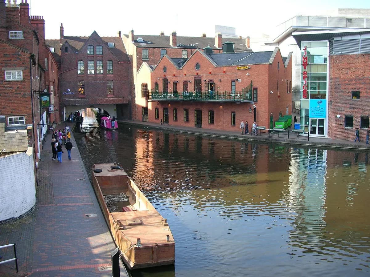 Birmingham: canal locks with narrowboats and brick towpath bridges, modern towers behind