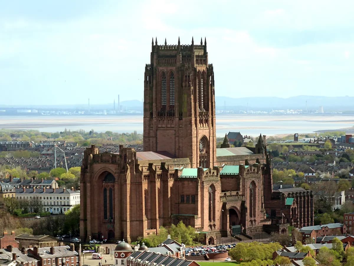Liverpool: a waterfront building with two clock towers topped by birds, a ferry on the river